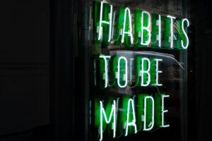 11neon sign in green displaying phrase habits to be made